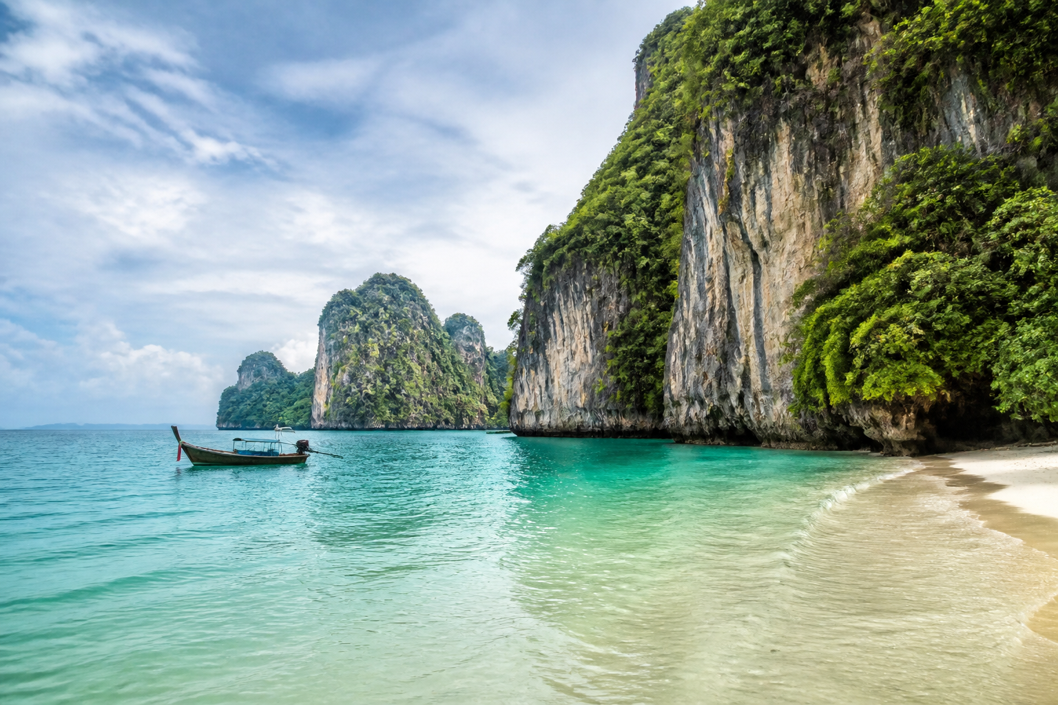 Andamanenküste bei Krabi mit Kalksteinfelsen und Longtail-Boot
